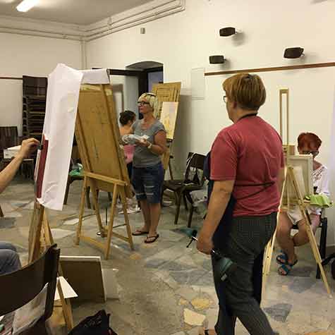 Udeleženci med slikanjem v slikarsko risarski poletni delavnici.