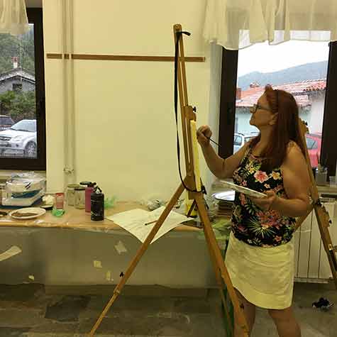 Udeleženka Poletne slikarske delavnice 2020 med slikanjem.