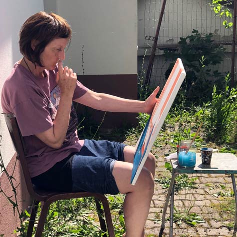 Udeleženka Sabina med slikarskim ustvarjanjem v poletni slikarski delavnici, ki je namenjena odraslim ljubiteljem slikarstva.