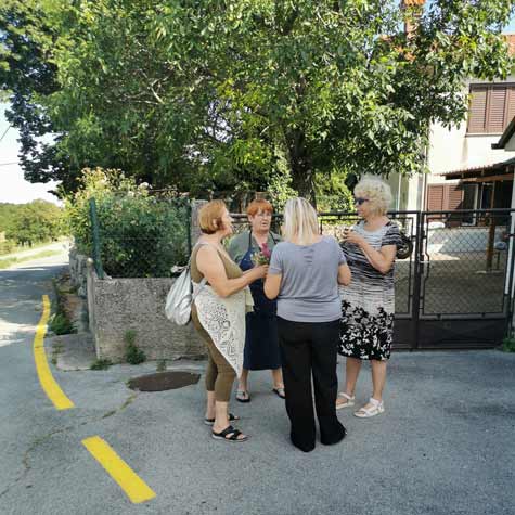 Udeleženke slikarske šole med sproščenim klepetom pred slikarskim delom.